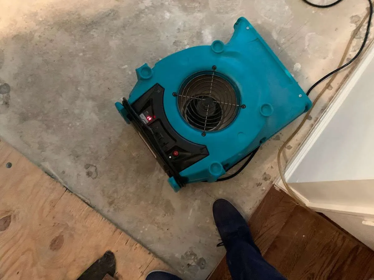 Air mover drying subfloor during Commercial Water Damage Restoration in Hanford